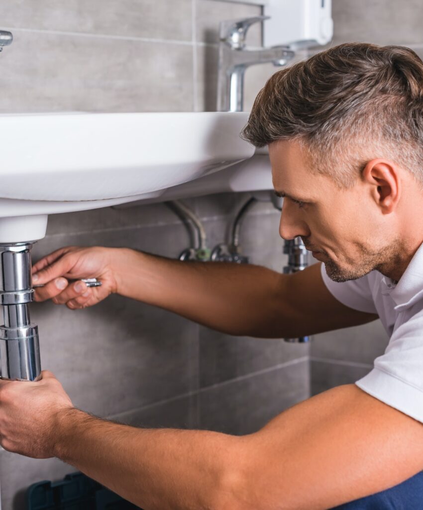 adult-plumber-fixing-sink-at-bathroom.jpg